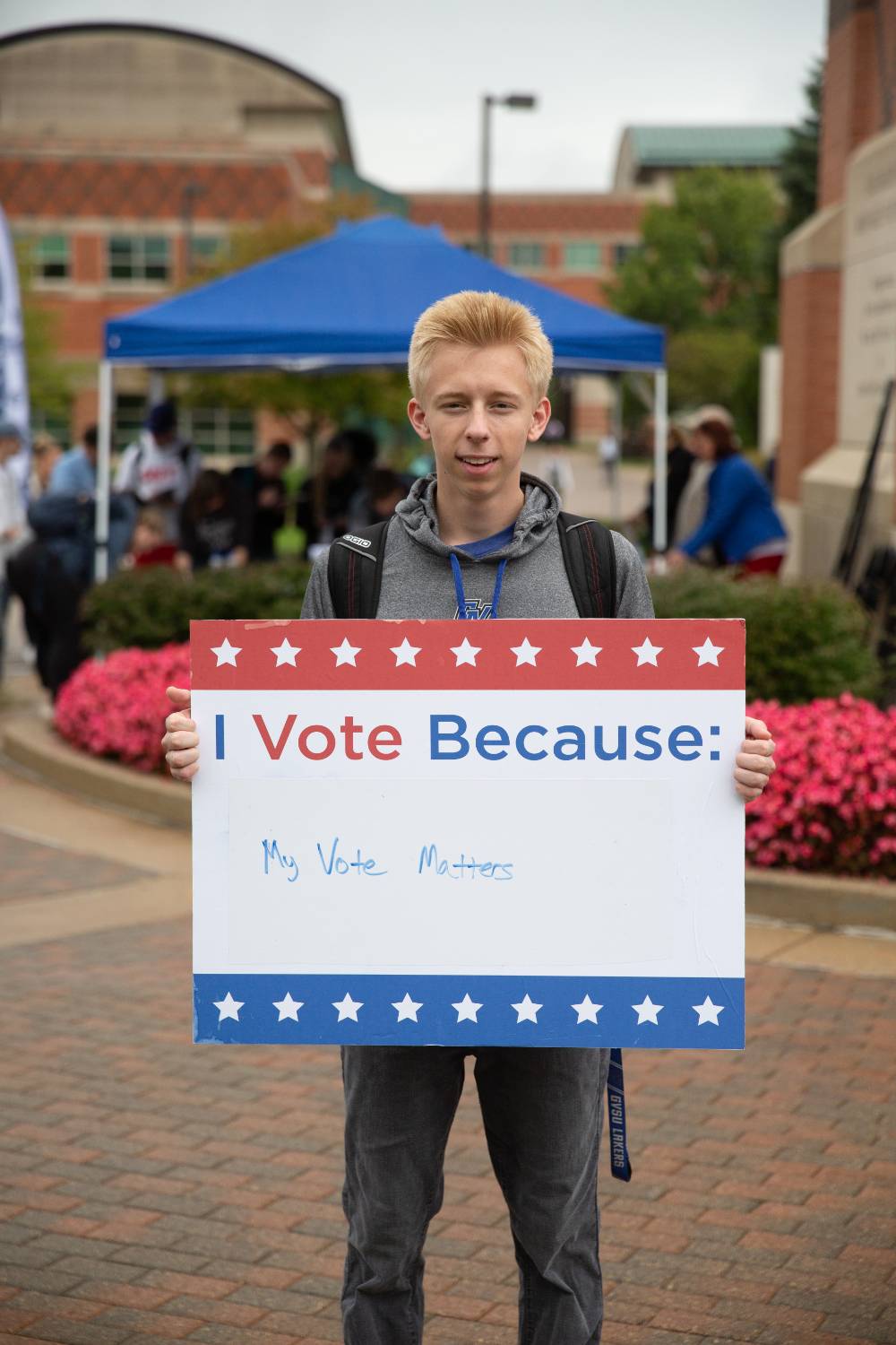 Student holding sign titled "I vote because: my vote matters"
